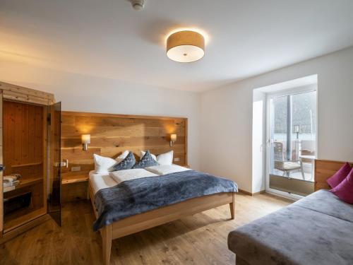 a bedroom with a large bed with a wooden headboard at Appartements Am Achensee in Pertisau