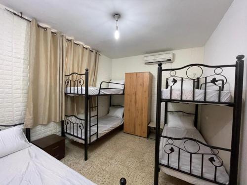 mały pokój z 2 łóżkami piętrowymi i pokój z łóżkiem w obiekcie YCC Guesthouse w mieście Nablus