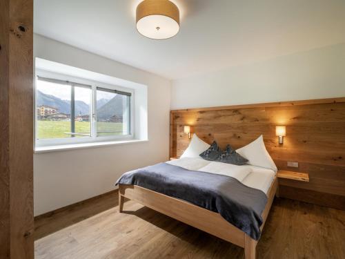 ein Schlafzimmer mit einem großen Bett und einem Fenster in der Unterkunft Appartements Am Achensee in Pertisau
