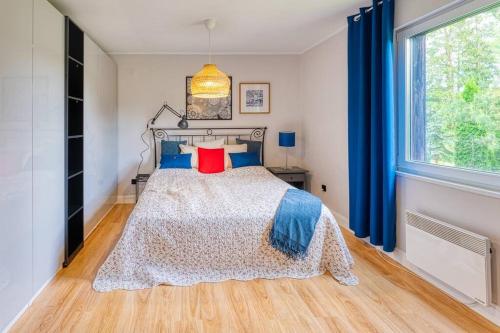 a bedroom with a bed with blue curtains and a window at Letni dom nad jeziorem Kaszuby Trójmiasto in Bieszkowice