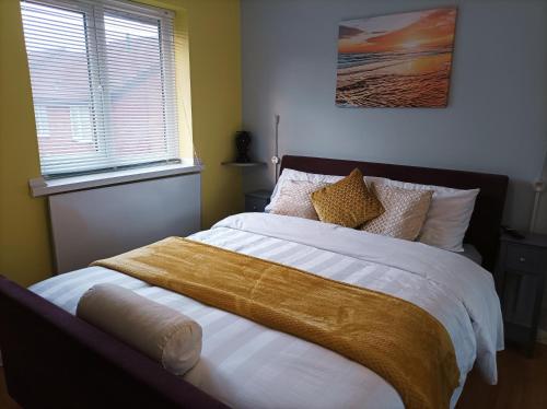 a bedroom with a large bed with a yellow blanket at Very Peaceful Semi Detached Home Stoke on Trent in Rough Close