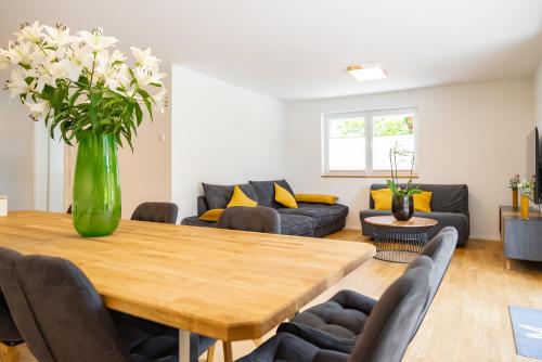 una sala de estar con una mesa de madera y un jarrón de flores en Mit c en Feldberg