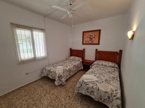 a bedroom with two beds and a ceiling fan at Capistrano1 in Nerja