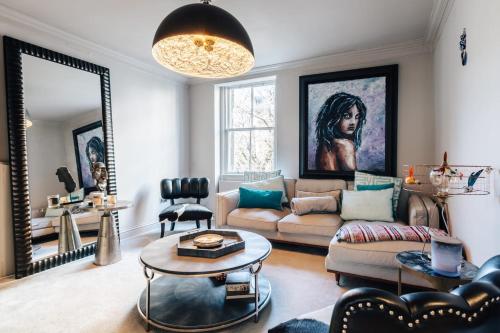 a living room with a couch and a mirror at Stunning central Bath Apartment in Bath