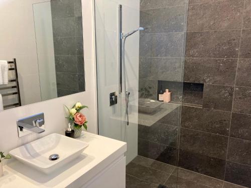 a bathroom with a sink and a glass shower at Highview terrance 3 bedrooms house queenstown in Queenstown