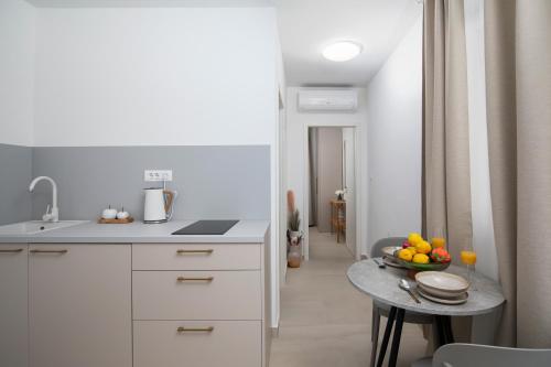 Apartments and rooms Jakić في ميدولين: مطبخ مع طاولة عليها صحن من الفواكه