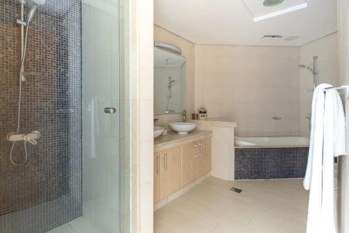 y baño con ducha, lavabo y bañera. en Frank Porter - Al Nabat, Shoreline 8, en Dubái