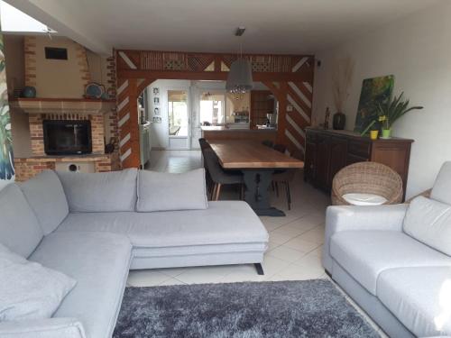 - un salon avec deux canapés blancs et une table dans l'établissement Chez Béa, à Saint-Ouen-en-Belin