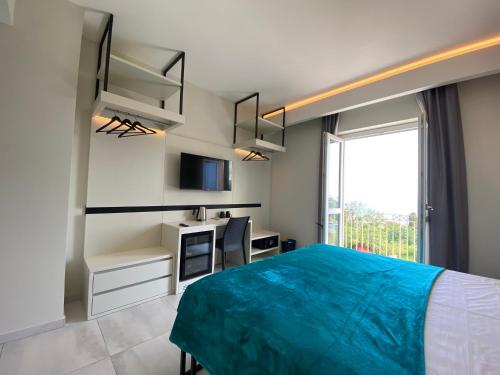 a bedroom with a blue bed and a window at Aether Suites Tropea - Free Private Parking in Tropea