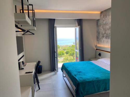 a bedroom with a bed and a desk and a window at Aether Suites Tropea - Free Parking in Tropea