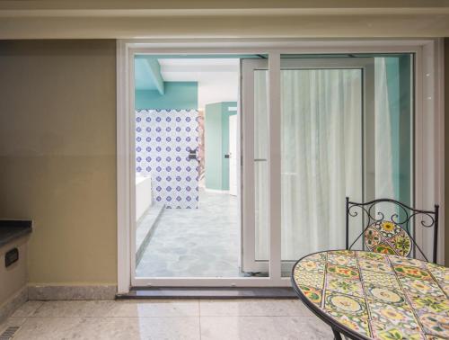 a dining room with a table and a glass door at Gioia Home in Pompei