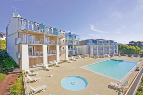 - une vue aérienne sur un bâtiment avec une piscine dans l'établissement Lagrange Vacances - Les Terrasses de l'Océan, à Audierne