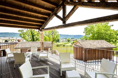 una terraza con sillas blancas y una mesa en Borgo Case Marian, en Cison di Valmarino