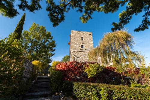 a tower in the middle of a garden with flowers at MarcheAmore - La Roccaccia relax, art & nature in Montefortino