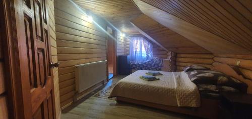 a bedroom with a bed in a log cabin at Прутець in Mykulychyn