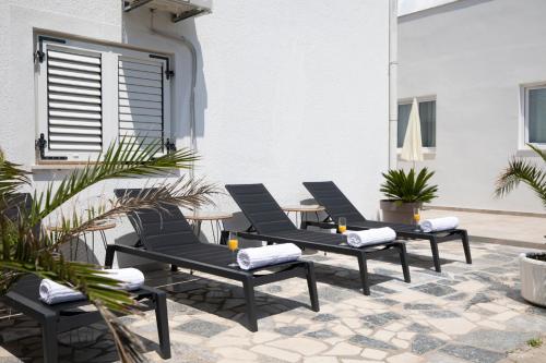 a group of chairs sitting on a patio at Apartments and rooms Jakić in Medulin