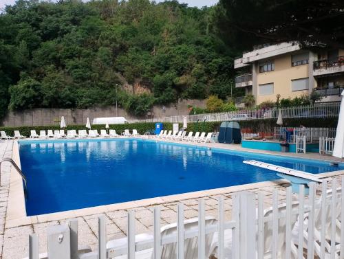 una gran piscina con sillas blancas y un edificio en Salgari209, en Génova