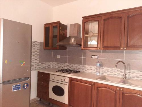 uma cozinha com armários de madeira e um frigorífico de aço inoxidável em Trilocale Serra Li Lioni - Sassari em Sassari