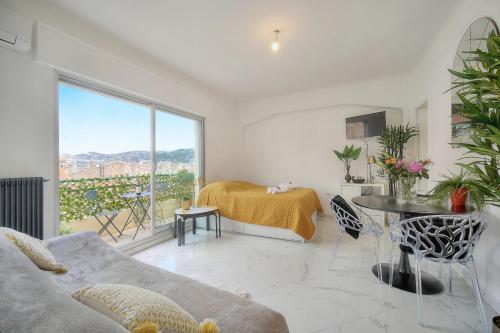 - un salon avec un canapé, un lit et une fenêtre dans l'établissement STUDIO LUMINEUX 200 m DES PLAGES A0B192, à Cannes