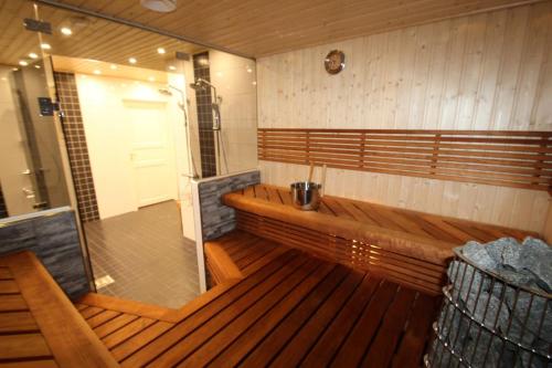 Großes Zimmer mit Holzbänken und einer Tür in der Unterkunft Villa Kupsala , LaatuLomat in Juva