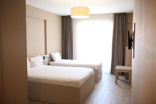 a hotel room with two beds and a window at Cinas Hotel in Eskisehir