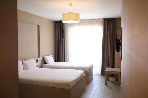 a hotel room with two beds and a window at Cinas Hotel in Eskisehir
