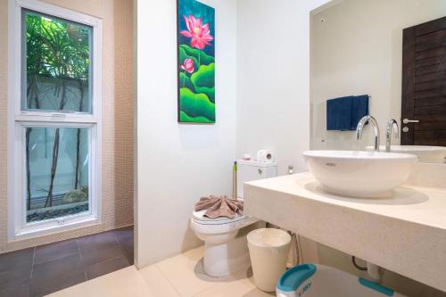 a bathroom with a sink and a toilet with a window at Balinese Style 3BR Villa Morning Forest, Nai Harn in Rawai Beach