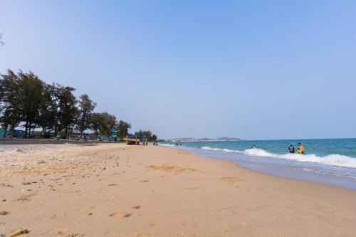 uma praia com pessoas caminhando na água em TTC Hotel Phan Thiet em Phan Thiet