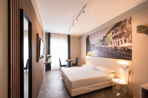 a hotel room with a bed and a painting on the wall at Kleos Hotel Milano in Milan