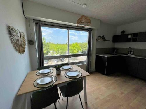 cocina con mesa con sillas y ventana grande en T2 rénové avec place parking privée et vue dégagée à Carnon, en Carnon-Plage