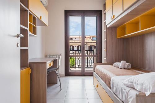 una camera con letto, scrivania e finestra di Casa Isola con Giardino by Wonderful Italy a Siracusa