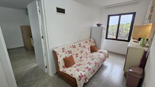 a living room with a couch and a window at Apartments Val Maslina in Utjeha