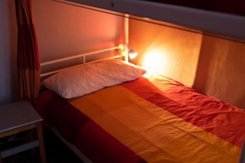 a bed in a room with a light on it at Manena Hostel Genova in Genova