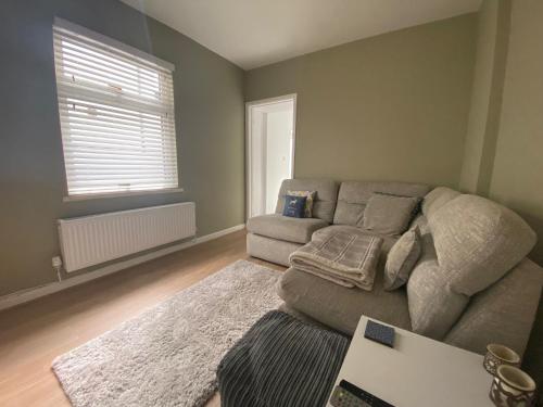 a living room with a couch and a window at Private double room in our Cardiff Home in Cardiff