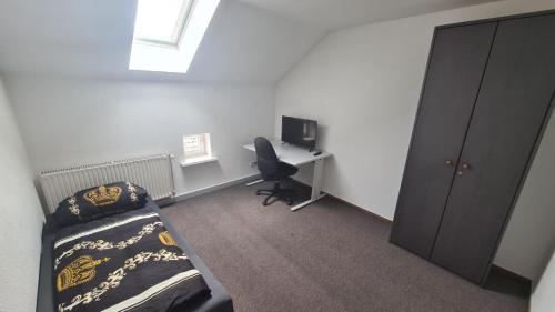 1 dormitorio con 1 cama y escritorio con ordenador en Ferienwohnung, en Nordhausen