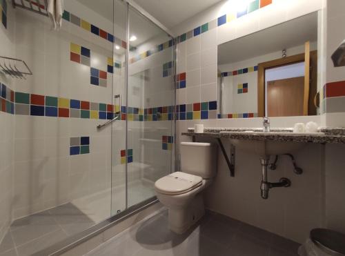 uma casa de banho com um WC, um chuveiro e um lavatório. em Hostal Mayor 71 em El Burgo de Osma