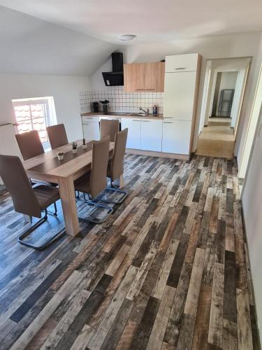 cocina y comedor con mesa de madera y sillas en Ferienwohnung, en Nordhausen