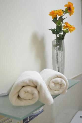 twee handdoeken op een plank naast een vaas met bloemen bij Apartamentos Garden Atlantis en Club Atlantis in Adeje