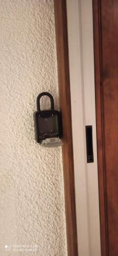 un sac à main noir accroché au mur à côté d'une porte dans l'établissement studio1 Bagnères de Bigorre, à Bagnères-de-Bigorre