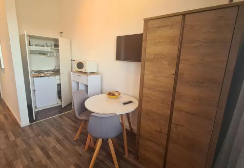 a small room with a table and chairs and a refrigerator at Horn Gästehaus in Leinfelden-Echterdingen