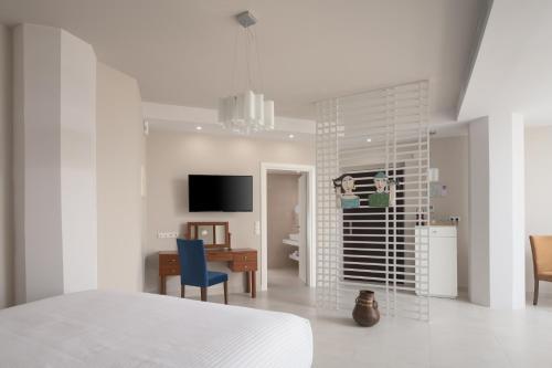 a white room with a bed and a desk and a table at Macaris Suites & Spa in Rethymno Town