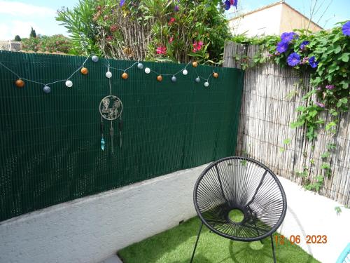 una recinzione verde con un ventilatore in un cortile di Maison cocooning à 1km de la mer a Saint-Cyprien