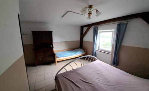 niewielka sypialnia z łóżkiem i oknem w obiekcie Śródziemie Lorien w mieście Leśno