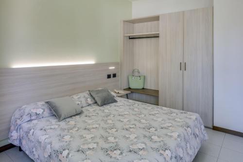 a bedroom with a large bed and a cabinet at Residence Villaggio Tiglio in Sirmione
