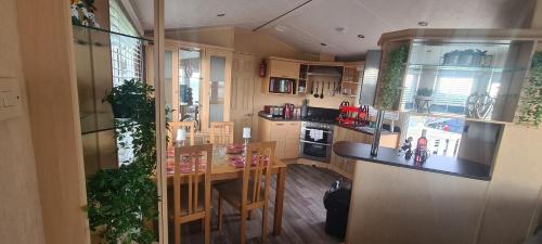 a kitchen with a counter and a table with chairs at Diamond Lodge in Millom