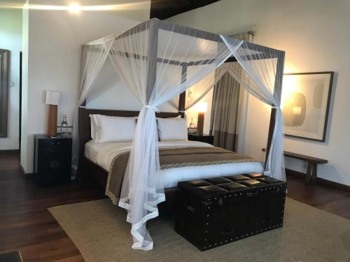 a bedroom with a bed with a canopy at The Postcard Galle in Galle