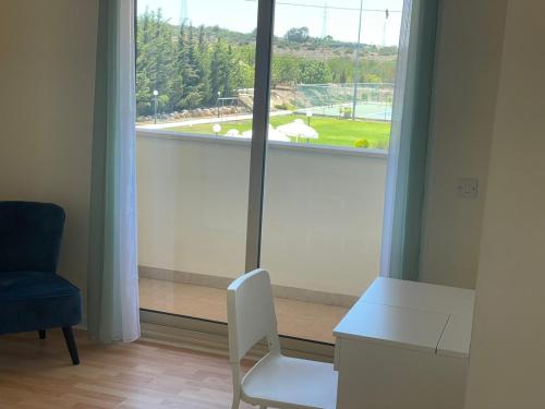 a white chair sitting in front of a window at Protaras Tennis and Country Club in Protaras