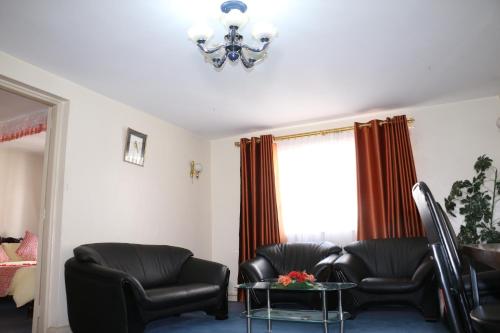 a living room with two chairs and a table and a chandelier at Adventist LMS Guest House & Conference Centre in Nairobi