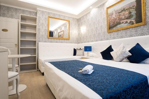 a hotel room with a bed with a hat on it at Royal Verona Relais in Verona