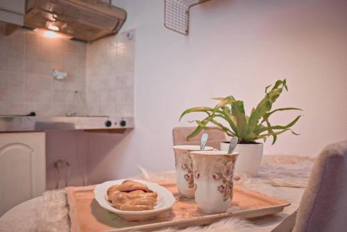a table with a plate of food and a plant at Ruby Apartment in Agios Nikolaos